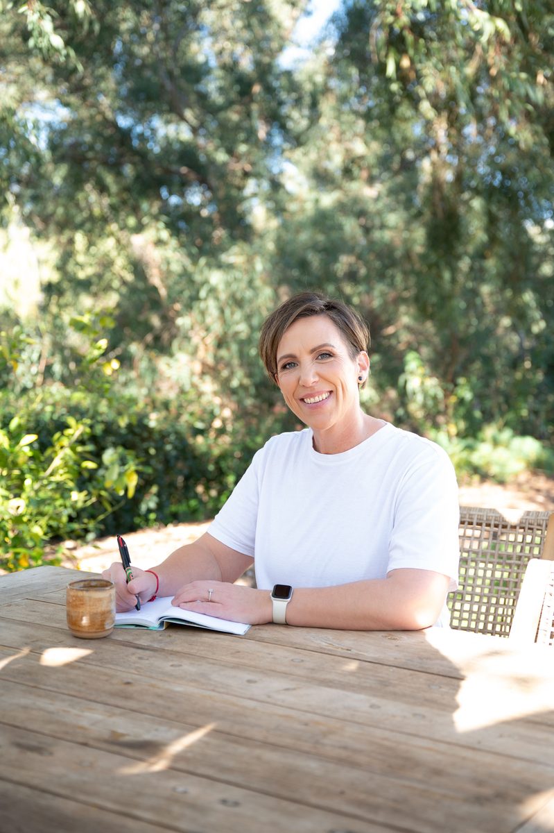 Anita Gibbons writing in her journal outdoors