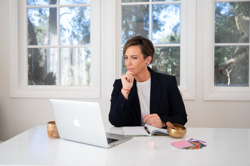 Anita Gibbons listening thoughtfully during an online session at her desk